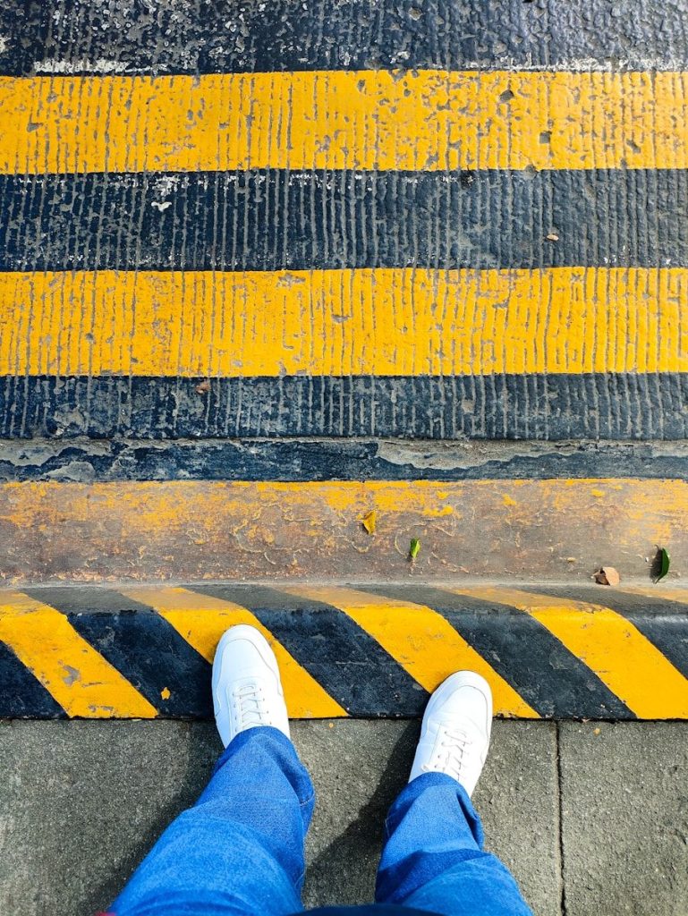 A person standing in front of a yellow and black stripe